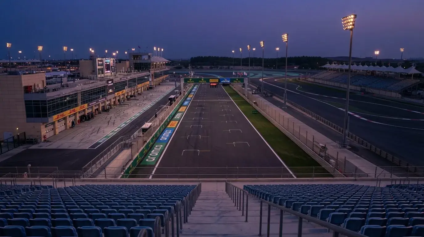 An empty football stadium with floodlight masts at dusk